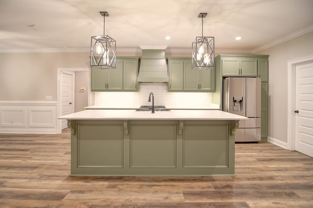 3039 Mary Powell Way, Hahira, GA 31632 - kitchen featuring green cabinets, refrigerator with ice dispenser, custom range hood, light countertops, and crown molding