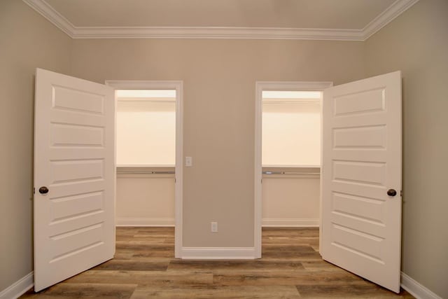3039 Mary Powell Way, Hahira, GA 31632 - unfurnished bedroom with ornamental molding, a walk in closet, wood finished floors, a closet, and baseboards