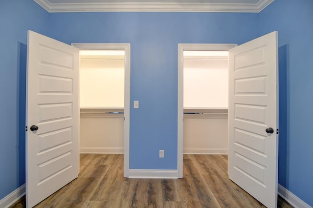 3039 Mary Powell Way, Hahira, GA 31632 - unfurnished bedroom with a walk in closet, a closet, wood finished floors, and crown molding
