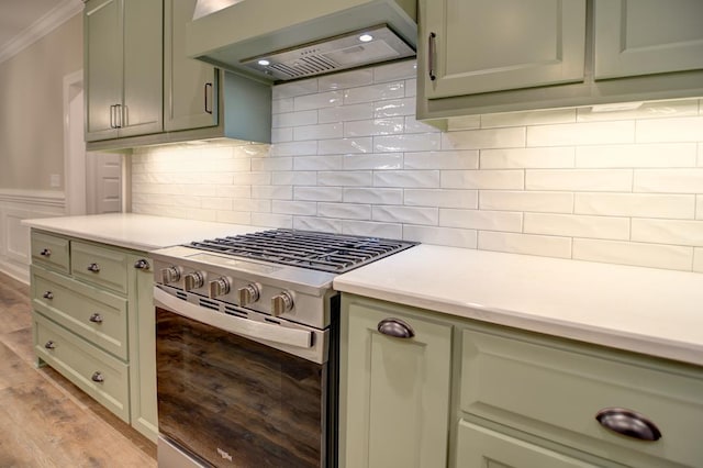 3039 Mary Powell Way, Hahira, GA 31632 - kitchen with gas stove, custom exhaust hood, light countertops, light wood-style flooring, and ornamental molding