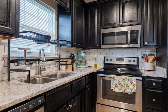 5187 Calvary Cir, Valdosta, GA 31605 - kitchen with appliances with stainless steel finishes, dark cabinets, decorative backsplash, and light stone counters