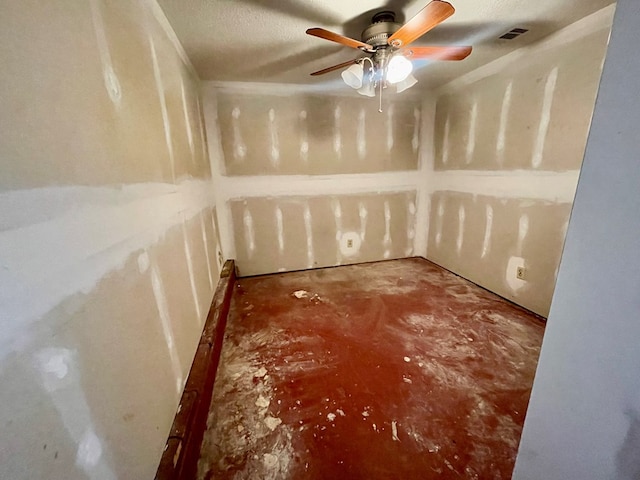 spare room with visible vents, ceiling fan, and concrete floors