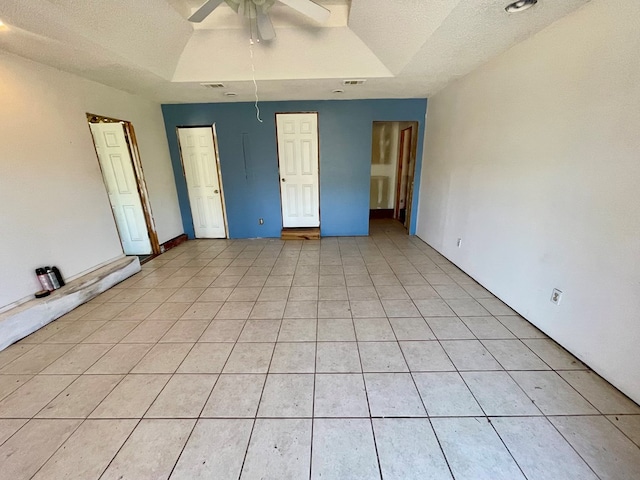 unfurnished bedroom featuring light tile patterned floors, a textured ceiling, visible vents, and ceiling fan