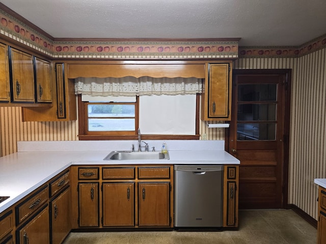 kitchen with sink, stainless steel dishwasher, and a textured ceiling