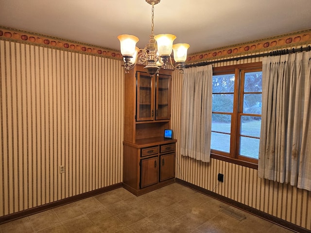 unfurnished dining area with a chandelier