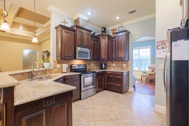 5080 Carlton Ridge Cir, Hahira, GA 31632 - kitchen with appliances with stainless steel finishes, arched walkways, crown molding, tasteful backsplash, and pendant lighting