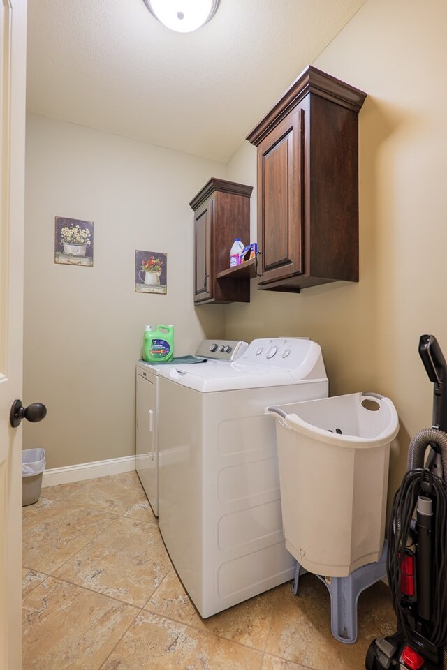 5080 Carlton Ridge Cir, Hahira, GA 31632 - laundry area with washing machine and clothes dryer, cabinet space, and stone tile floors