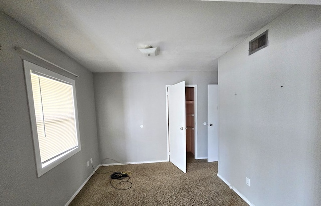 empty room with baseboards, carpet flooring, and visible vents