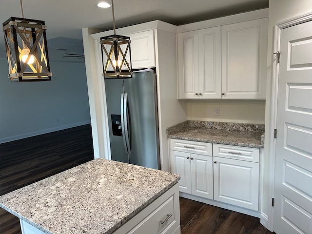 kitchen featuring pendant lighting, light stone counters, white cabinets, and stainless steel refrigerator with ice dispenser