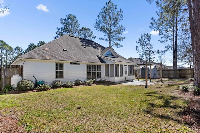 back of house featuring a yard, a patio area, a fenced backyard, and a sunroom