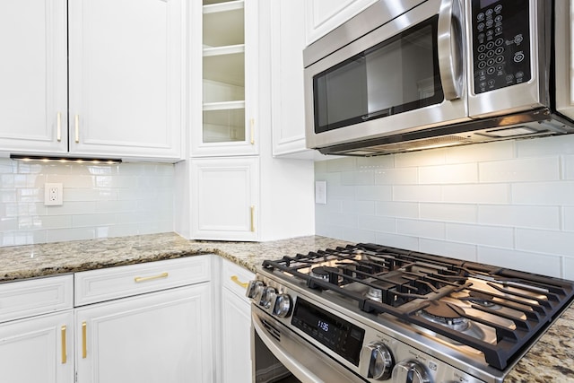 kitchen with stainless steel appliances, white cabinets, and glass insert cabinets