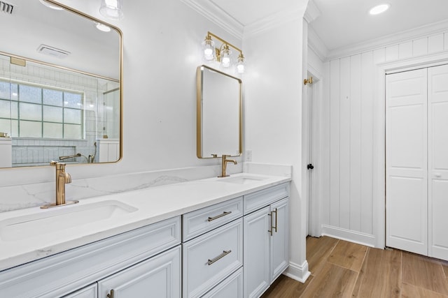 full bath with a shower stall, ornamental molding, a sink, and wood finished floors