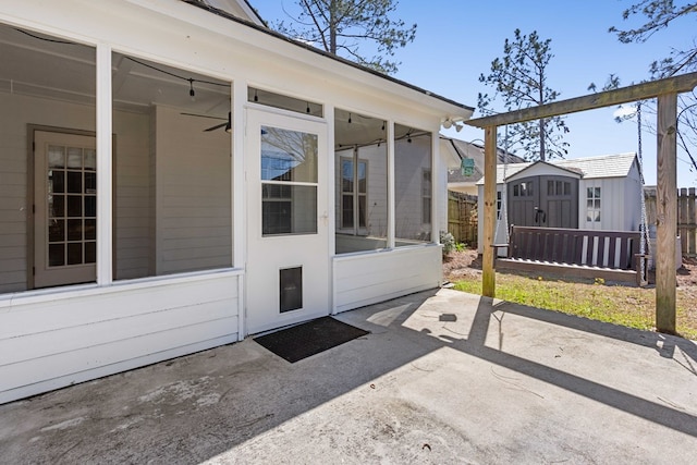 view of exterior entry with a patio area and fence