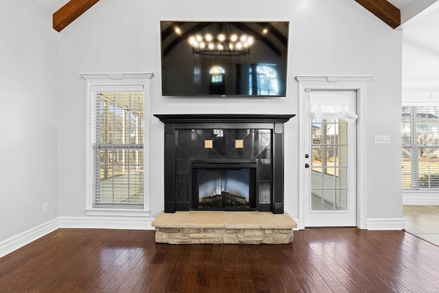 interior details with baseboards, a fireplace with raised hearth, and wood finished floors