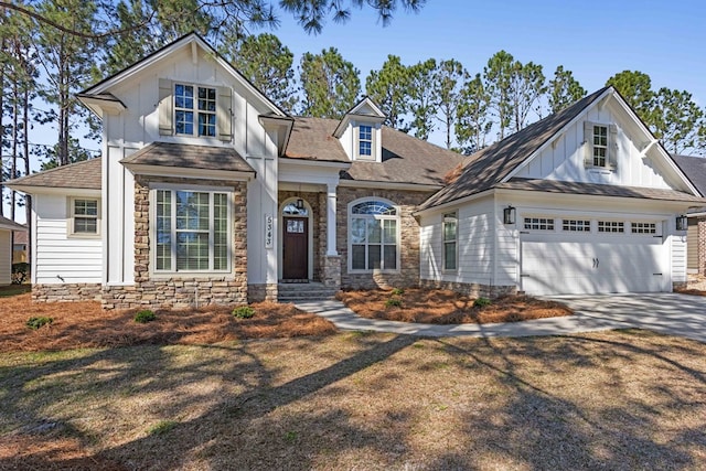 view of front of house featuring a garage, driveway, board and batten siding, and stone siding