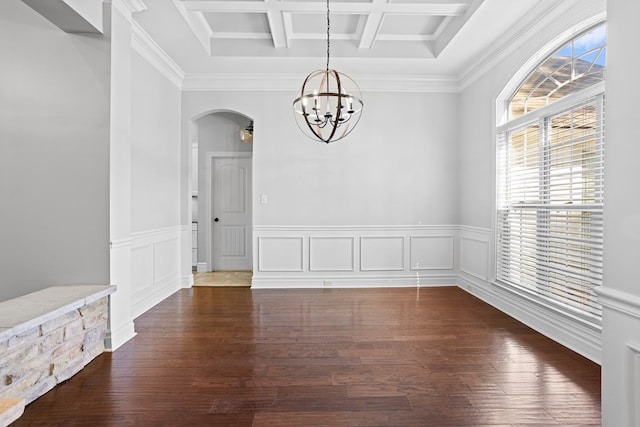 unfurnished dining area with arched walkways, coffered ceiling, dark wood-type flooring, an inviting chandelier, and beam ceiling