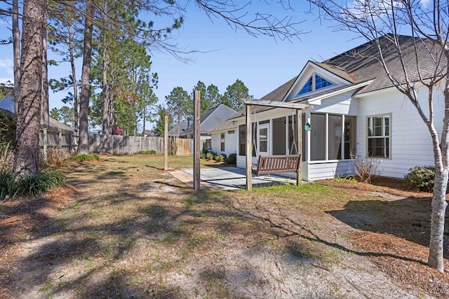 exterior space featuring a sunroom, a patio area, and fence