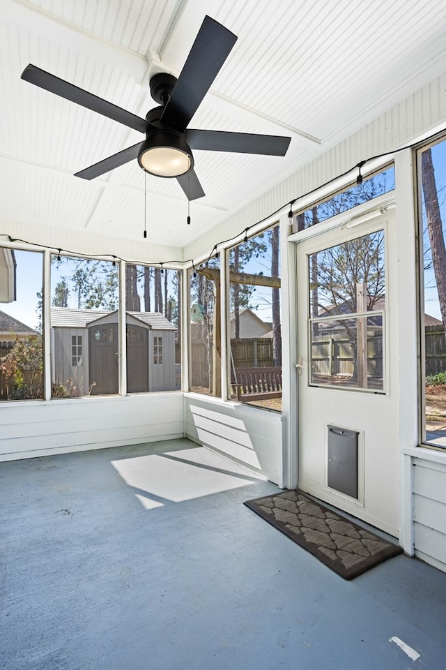 unfurnished sunroom with ceiling fan