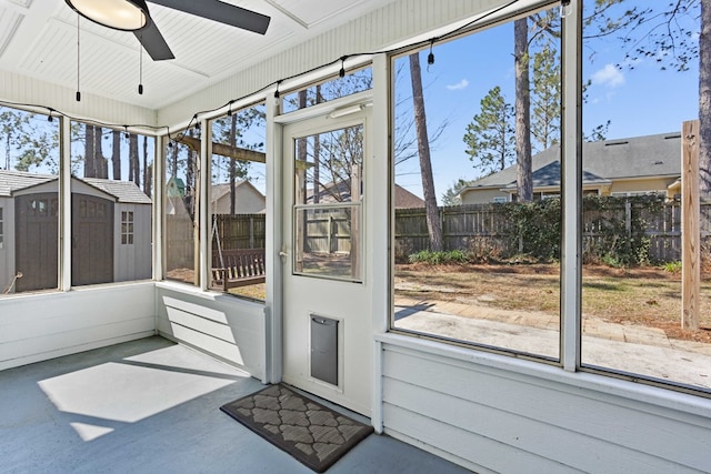 unfurnished sunroom featuring a ceiling fan and plenty of natural light