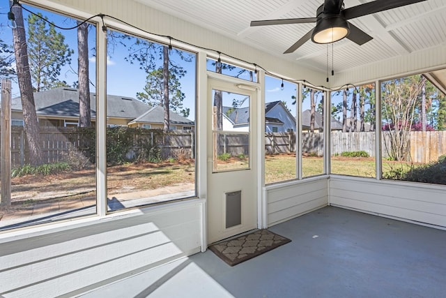 unfurnished sunroom featuring ceiling fan and a wealth of natural light