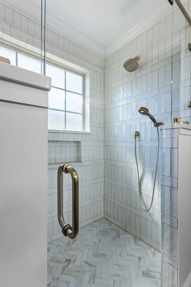 bathroom with tiled shower and crown molding