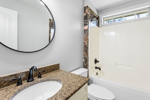 bathroom with bathtub / shower combination, vanity, and toilet