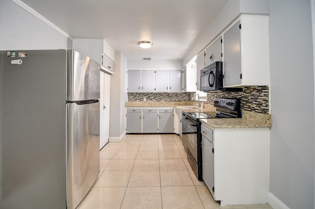 2321 Frederick Pl, Valdosta, GA 31602 - kitchen with black appliances, backsplash, light tile patterned floors, and white cabinetry