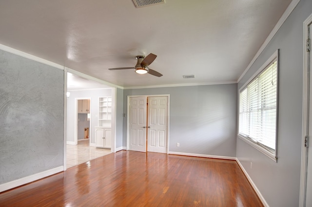 2321 Frederick Pl, Valdosta, GA 31602 - unfurnished bedroom featuring crown molding, wood finished floors, a closet, and a ceiling fan
