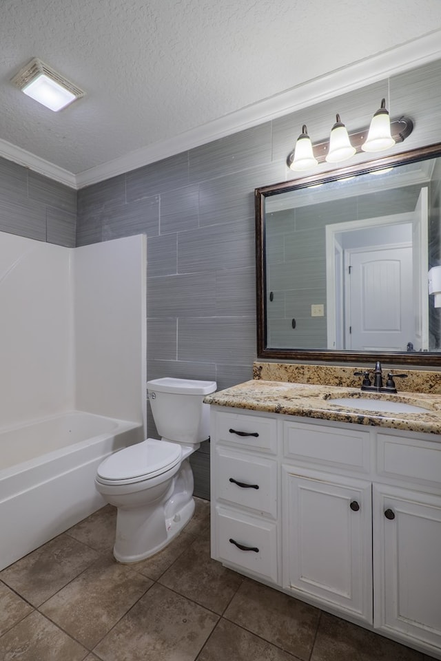 full bathroom with tile walls, tile patterned flooring, vanity, toilet, and a textured ceiling