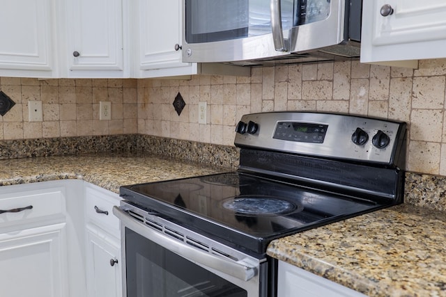 kitchen featuring stainless steel appliances, white cabinets, stone counters, and decorative backsplash