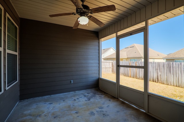 unfurnished sunroom with wood ceiling and ceiling fan