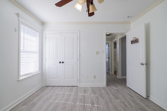 unfurnished bedroom featuring light hardwood / wood-style flooring, ceiling fan, ornamental molding, a textured ceiling, and a closet