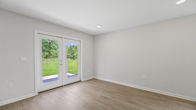 unfurnished room featuring recessed lighting, french doors, baseboards, and wood finished floors