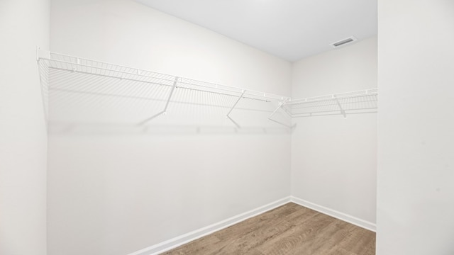 walk in closet with light wood-style flooring and visible vents