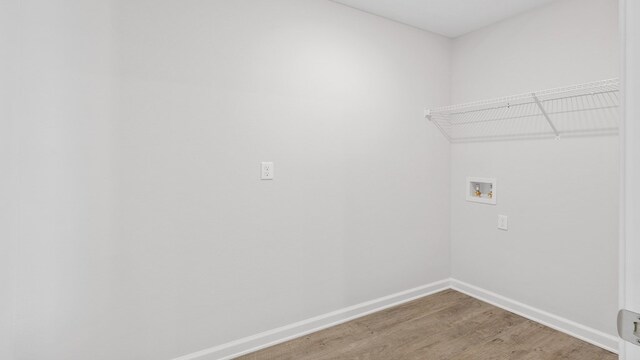 washroom with laundry area, baseboards, washer hookup, and light wood finished floors