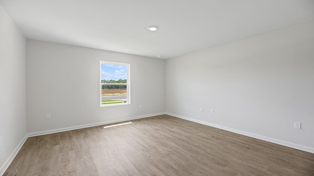 unfurnished room featuring wood finished floors and baseboards