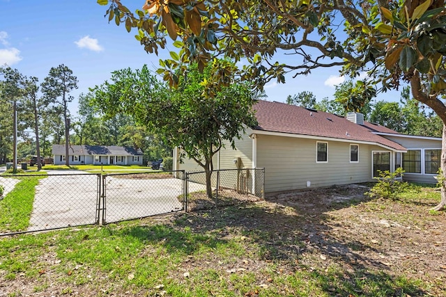 4312 Shiloh Trce, Valdosta, GA 31602 - view of home's exterior with a gate, fence, a chimney, and roof with shingles