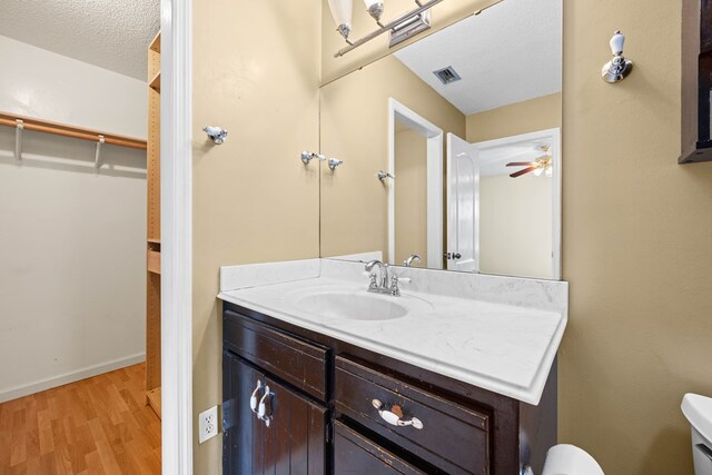 4312 Shiloh Trce, Valdosta, GA 31602 - half bathroom featuring wood finished floors, toilet, vanity, ceiling fan, and baseboards