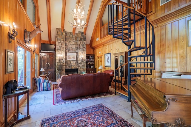 living room with an inviting chandelier, beamed ceiling, high vaulted ceiling, wooden walls, and a fireplace