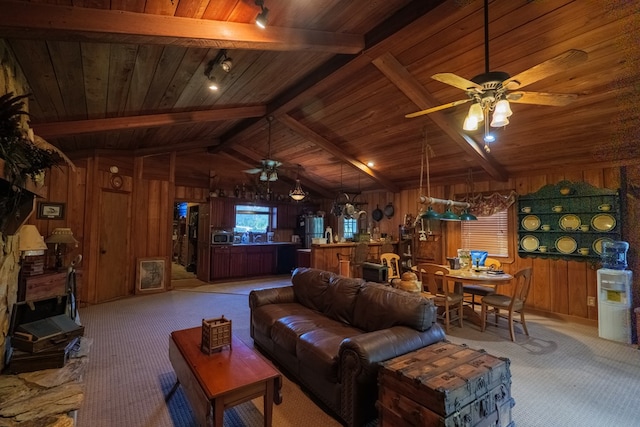 carpeted living room with vaulted ceiling with beams, wood walls, and wooden ceiling