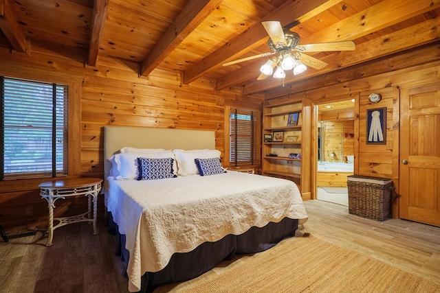 bedroom with beam ceiling, wood walls, ceiling fan, and wood-type flooring