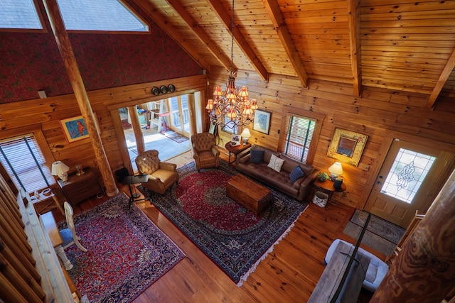 living room with hardwood / wood-style floors, high vaulted ceiling, and wooden walls