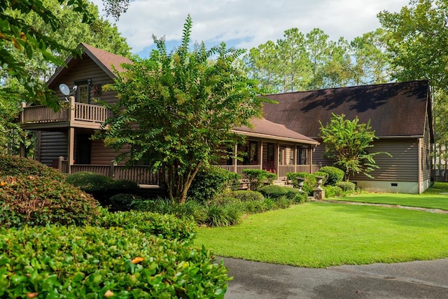 view of front of house featuring a balcony and a front lawn