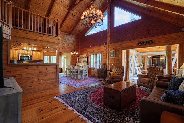 living room with plenty of natural light, beam ceiling, wood-type flooring, and high vaulted ceiling