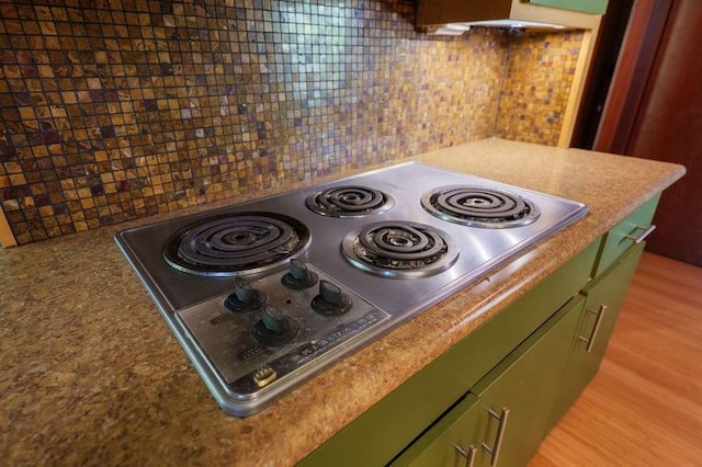 1614 N Patterson St, Valdosta, GA 31602 - room details with green cabinetry, stainless steel stovetop, backsplash, and ventilation hood