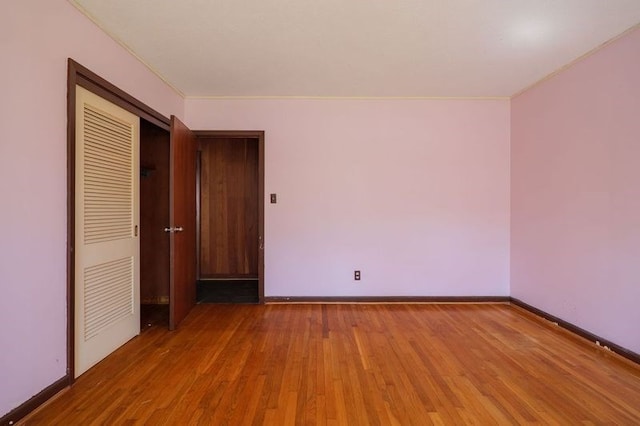 1614 N Patterson St, Valdosta, GA 31602 - unfurnished bedroom with a closet, baseboards, crown molding, and wood finished floors