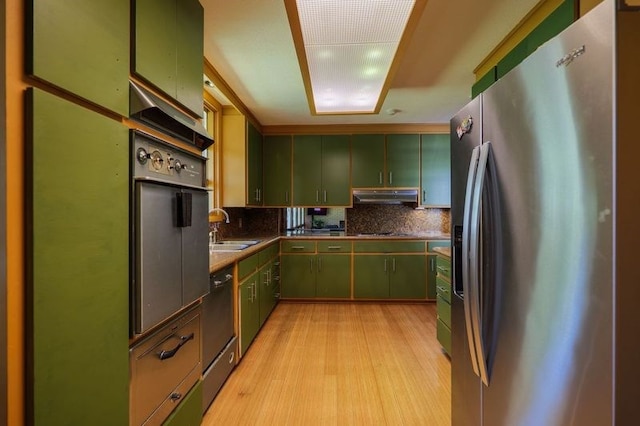 1614 N Patterson St, Valdosta, GA 31602 - kitchen featuring under cabinet range hood, black appliances, light wood finished floors, green cabinets, and decorative backsplash