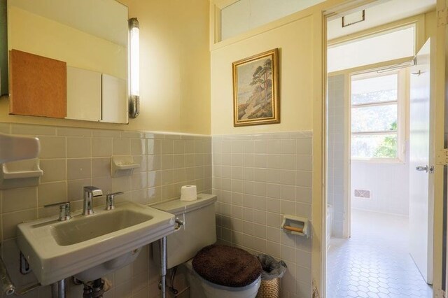 1614 N Patterson St, Valdosta, GA 31602 - bathroom with tile walls, a sink, and toilet
