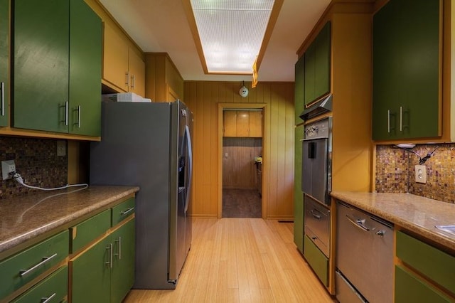 1614 N Patterson St, Valdosta, GA 31602 - kitchen with light wood-style floors, decorative backsplash, appliances with stainless steel finishes, and green cabinetry