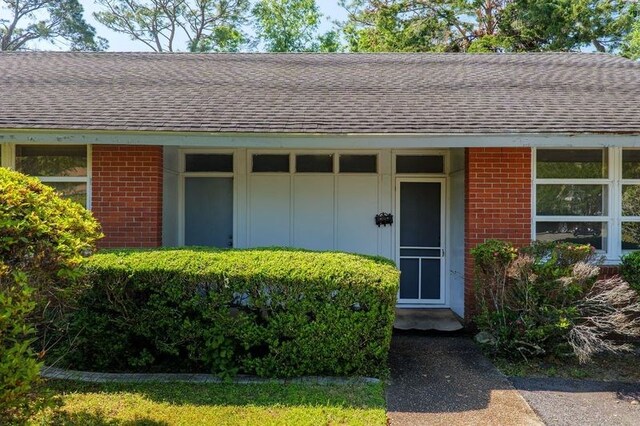 1614 N Patterson St, Valdosta, GA 31602 - property entrance with roof with shingles, board and batten siding, and brick siding